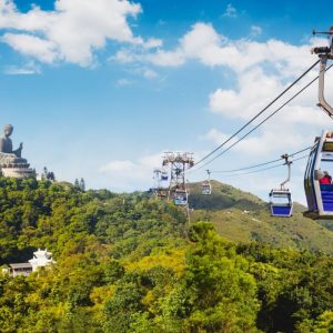 Ngong Ping cable car with big buddha statue in background, Hong Kong China